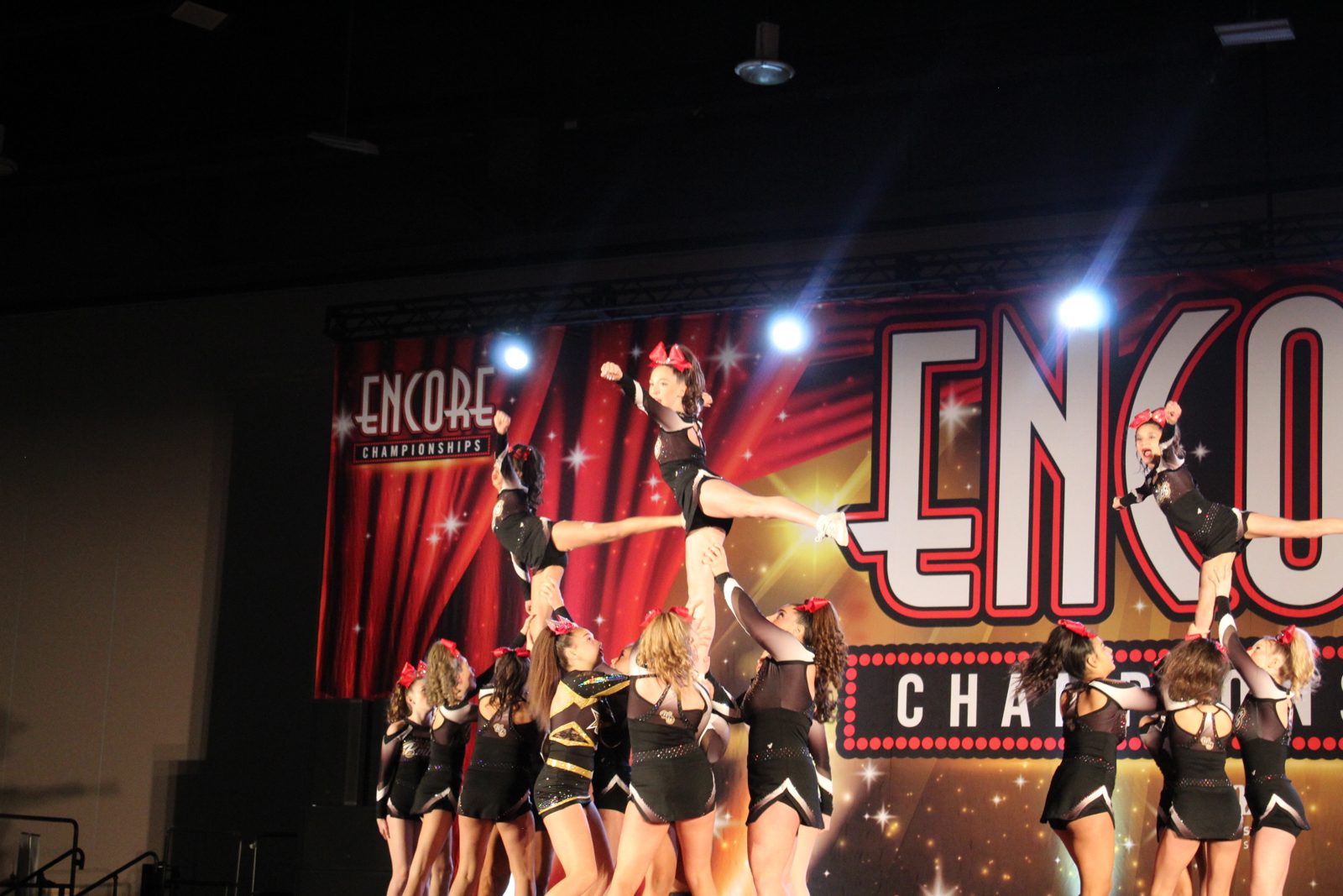 Kayla's cheer team performing on stage at Encore Championships