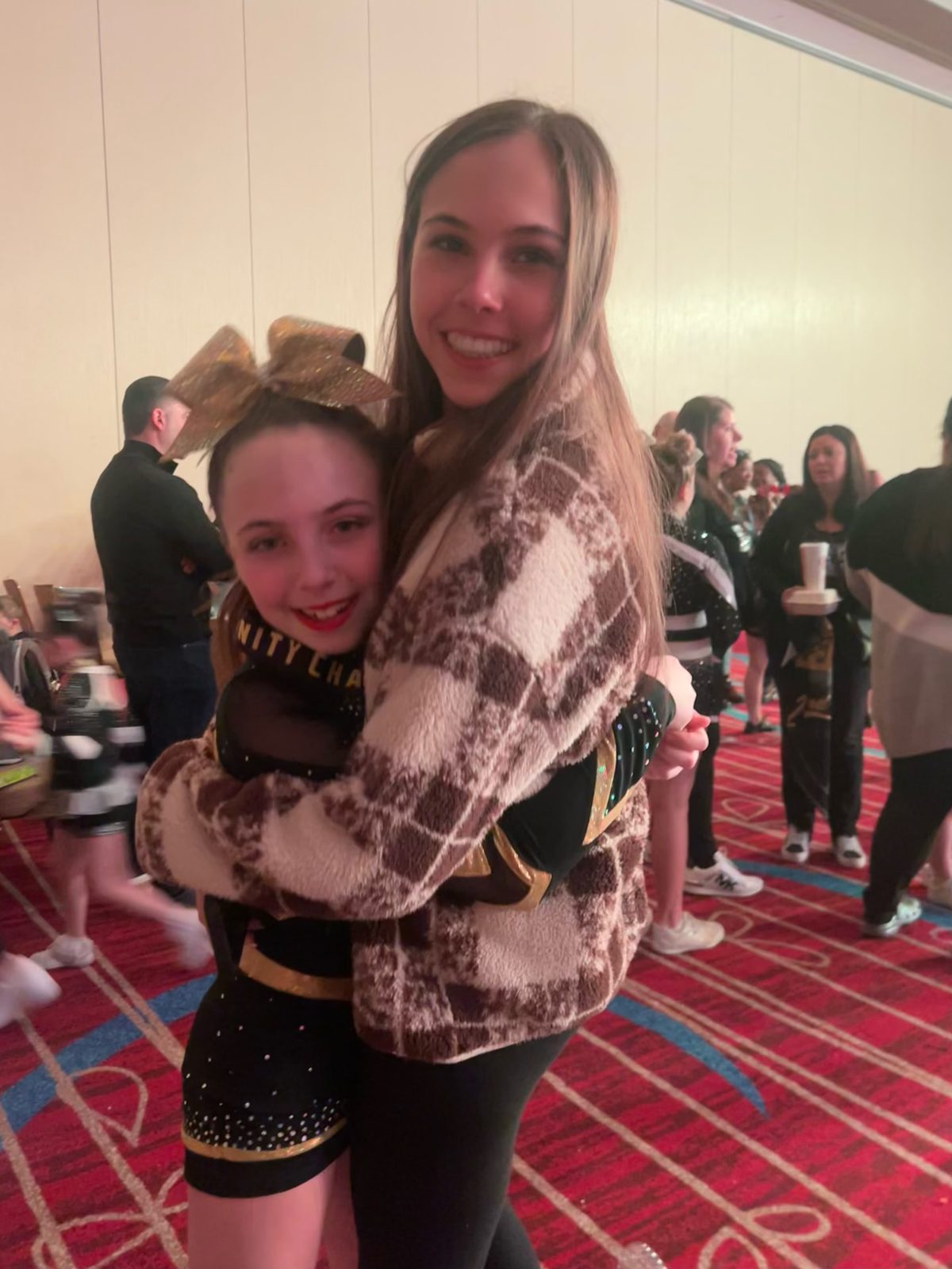 Kayla sharing a hug at a cheer competition