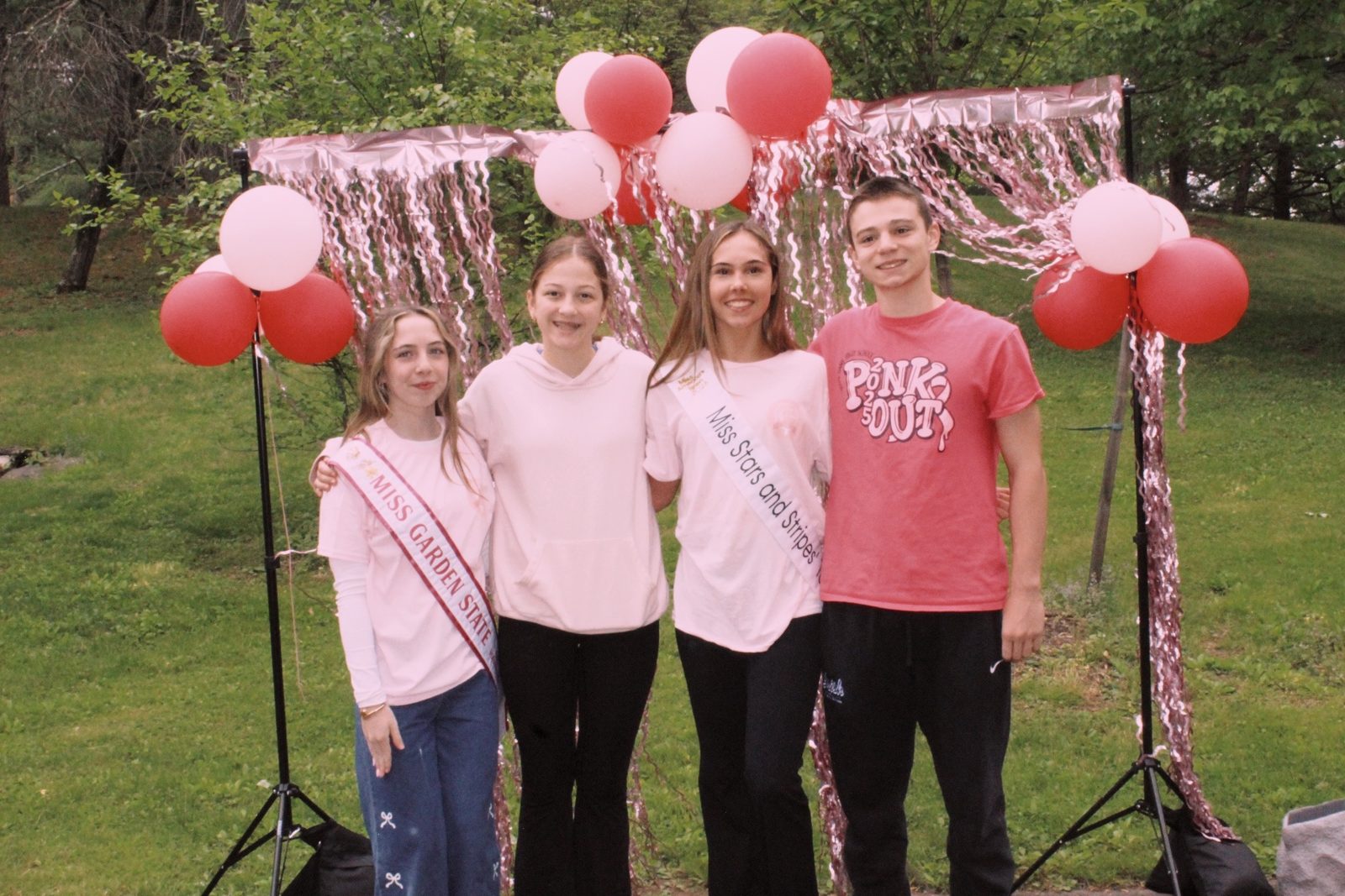 Kayla with friends at a pink balloon community event